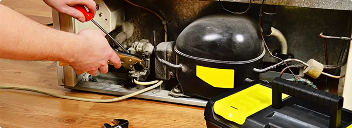 Refrigerator repair technician fixing the compressor and wiring in Fort Lauderdale, FL