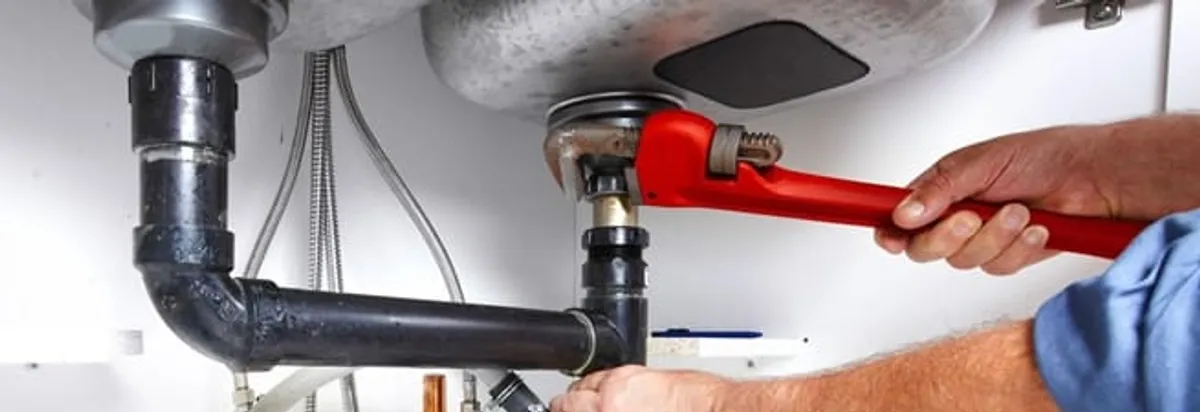Garbage disposal repair technician tightening the sink drain and disposal connection in Boca Raton, FL