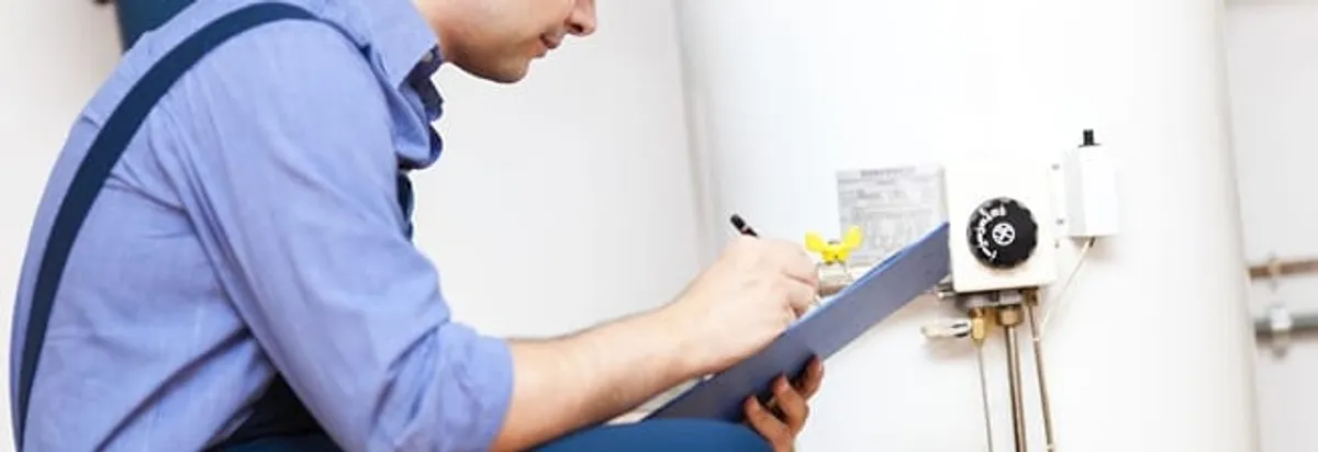 Water heater repair technician inspecting the unit and recording service notes in Boca Raton, FL